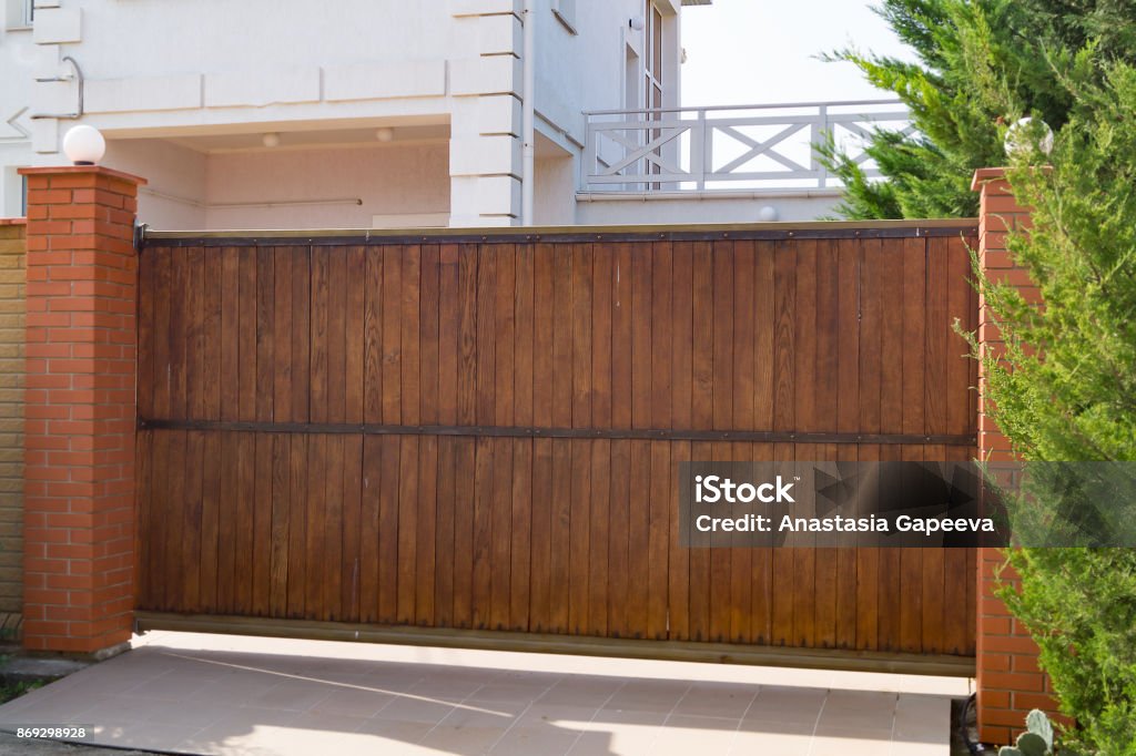 Brown automatic wooden gates of private house Gate Stock Photo