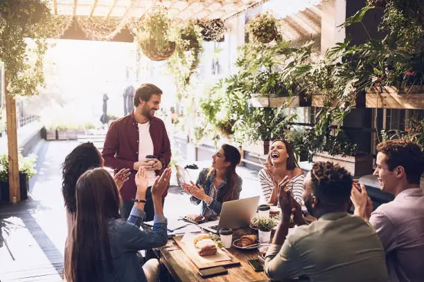 Shot of a group of creative workers having a meeting over lunch in a cafe