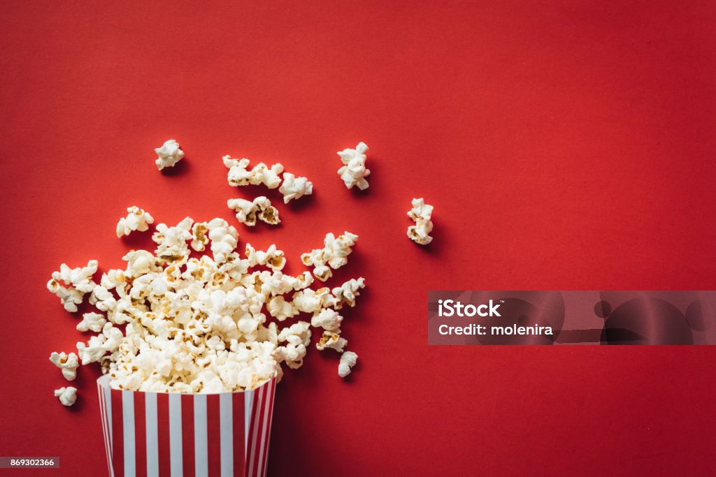 Striped box with popcorn Striped box with popcorn on red background Popcorn Stock Photo