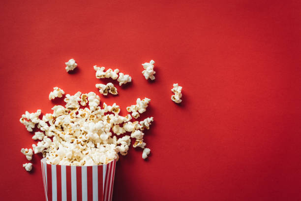 Striped box with popcorn Striped box with popcorn on red background popcorn stock pictures, royalty-free photos & images