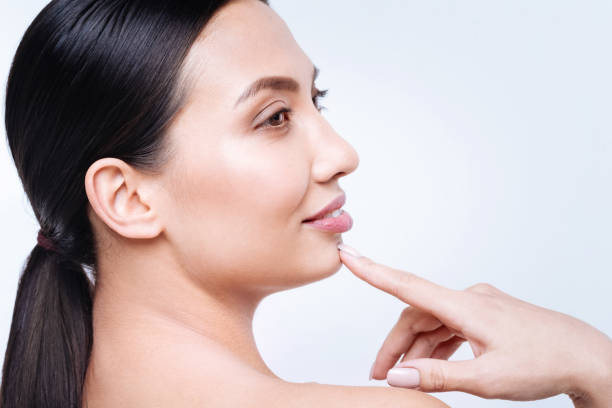 istock Side view of smiling brunette touching her chin with finger 869302936