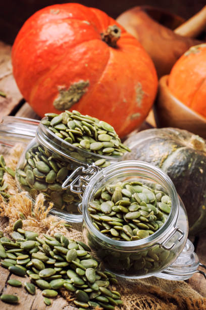 istock Raw pumpkin seeds in glass jars 869307026