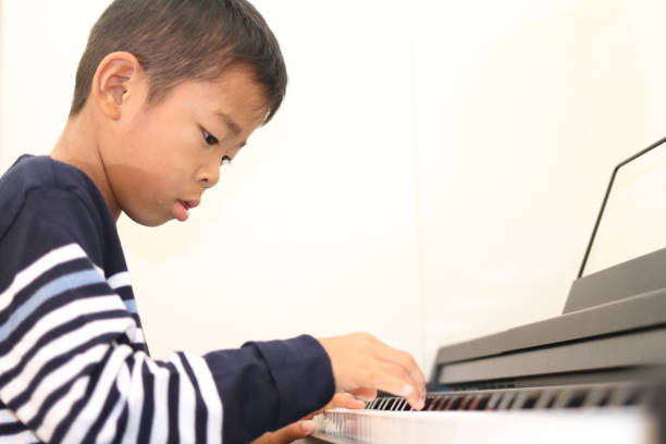 istock Japanese boy playing a piano (second grade at elementary school) 869307258