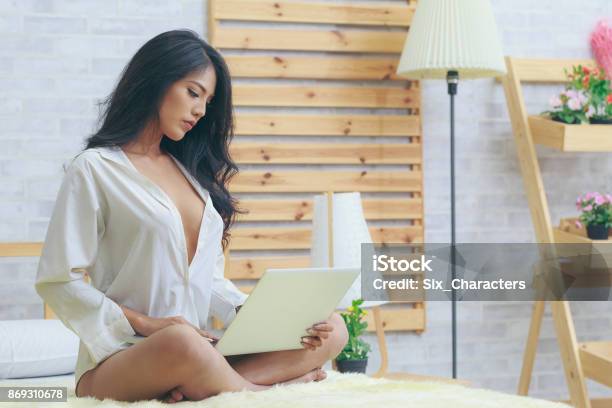 Asian Woman In White Shirt With Laptop In The Bedroom Stock Photo - Download Image Now