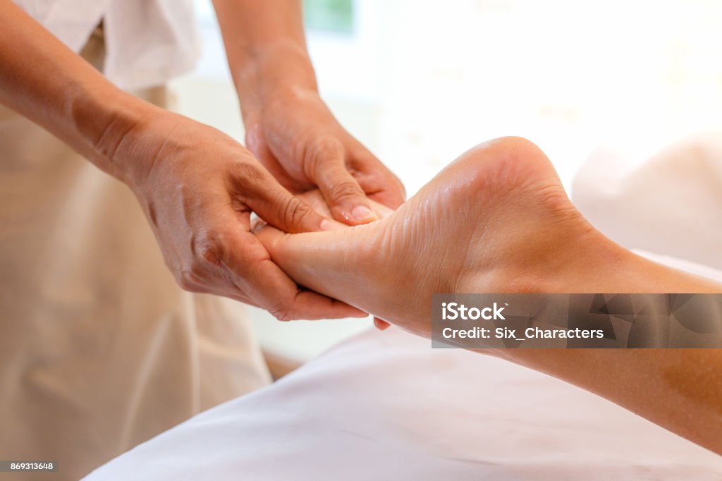 Young woman having foot massage in spa salon, close up Reflexology Stock Photo