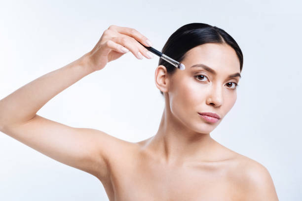 istock Beautiful brunette posing with a makeup brush 869318530