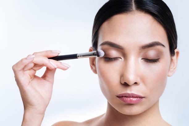 istock Charming woman applying eye shadows with brush 869318734