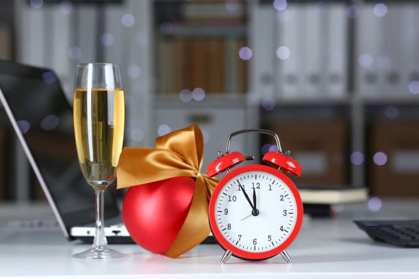 sveglia rossa e calice di champagne a tavola d'ufficio - wine christmas alcohol evening ball foto e immagini stock