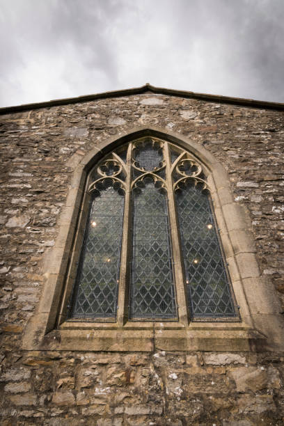 istock Church window with authentic gothic style and lights inside 869335118
