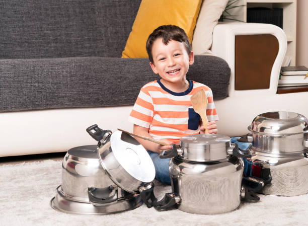 istock Cute child is playing cooking pans like a drums 869356028