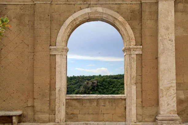 Photo of Italian view through the arch window in Sorano, Tuscany, Italy.