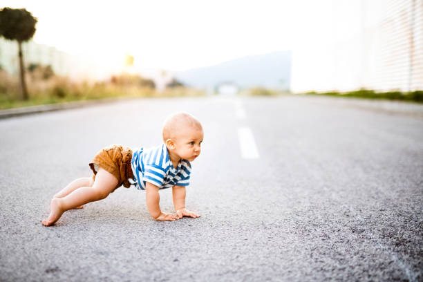 istock Little baby boy crawling outside on the road. 869359516