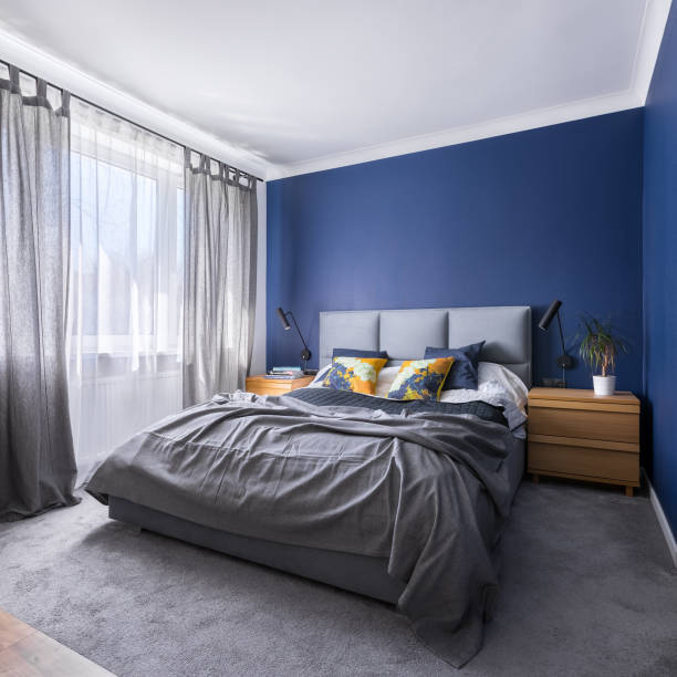 Cobalt blue bedroom with bed Modern, cobalt blue bedroom with double bed, gray bedding, carpet and window royal blue curtains stock pictures, royalty-free photos & images