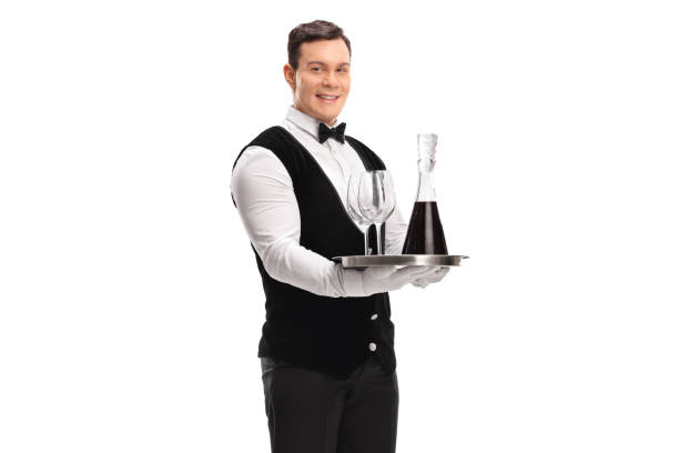 istock Waiter carrying a tray with red wine and two glasses 869368826