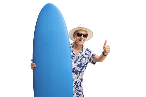 istock Elderly tourist with a surfboard making a thumb up sign 869371500