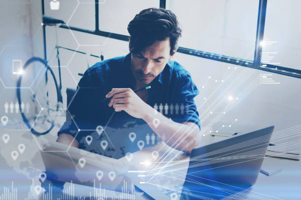 istock Concept of digital screen,virtual connection icon,diagram,graph interfaces.Young coworker working at coworking place on modern laptop.Businessman analyze stock reports.Blurred background,horizontal. 869372498