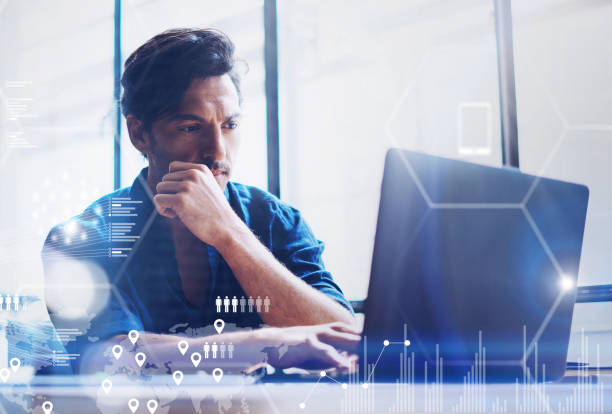 Concept of digital screen,virtual connection icon,diagram,graph interfaces.Young banking finance analyst working at office on laptop.Businessman analyze stock reports.Blurred background,horizontal.