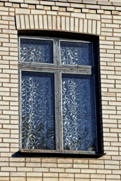 istock old window with a curtain on a gray brick wall 869379332