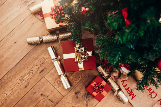 istock Gift boxes and Christmas crackers placed beside Christmas tree. 869386220
