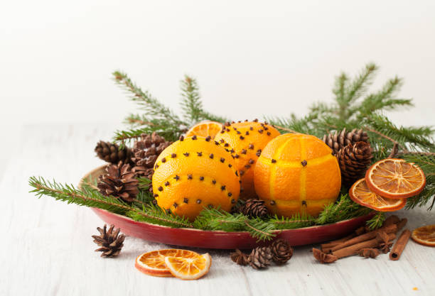 Decorated oranges with cloves on spruce branches with cones Oranges for decoration for the new year. Decorating oranges with cloves for the holiday. scent container stock pictures, royalty-free photos & images