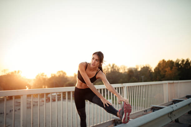 A young athletic woman is stretching out before beginning her daily workout routine.