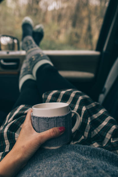 istock Woman holding a mug in car interior 869391342