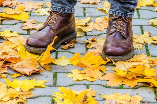 istock Autumn walk on the pavement. Brown boots 869397660