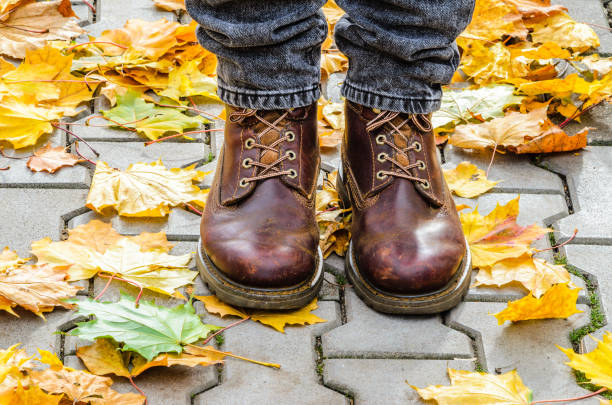 istock Autumn walk on the pavement. Brown boots 869398168