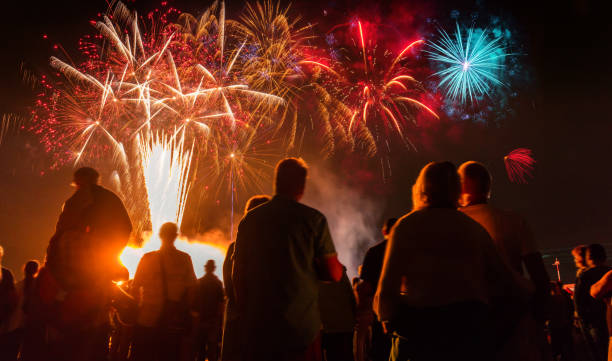 istock People standing  in front of colorful Firework 869405018