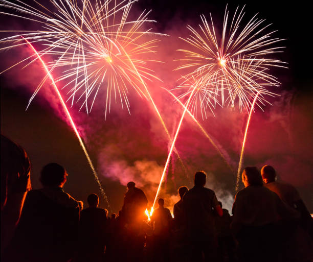 istock People standing  in front of colorful Firework 869405264