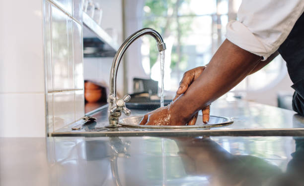 chef washing his hands in commercial kitchen - food hygiene imagens e fotografias de stock