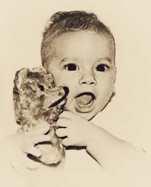 Vintage black and white  image of a cute and happy baby smiling straight to the camera.
