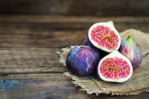 istock Ripe sweet figs on rustic wooden background 869415216