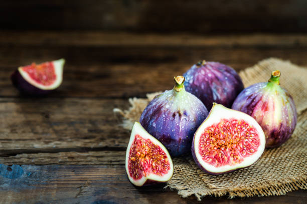istock Ripe sweet figs on rustic wooden background 869415368