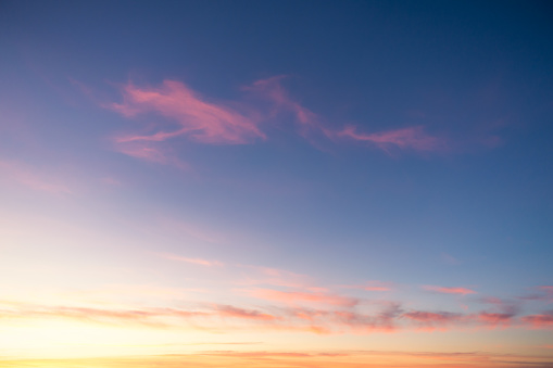 Wispy cirrus cloud above a golden sunset in Italy.