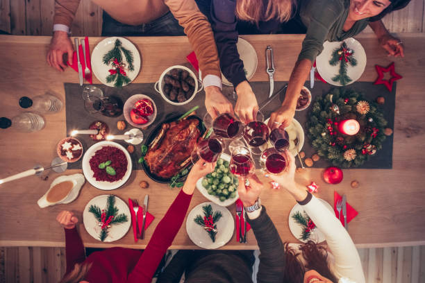 istock people clinking wine glasses at christmas table 869416480