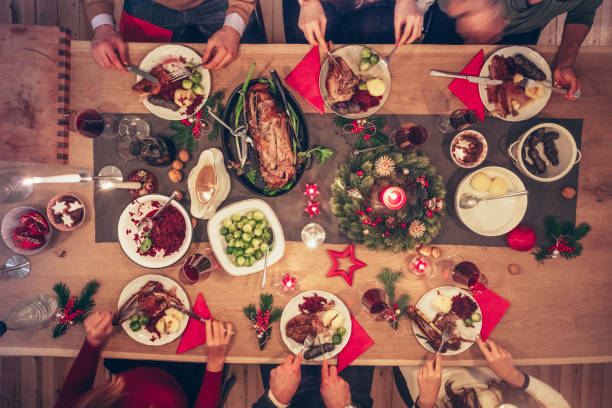 menschen, die traditionelle weihnachtsessen an festlichen holztisch essen - deutsche knödel draufsicht stock-fotos und bilder