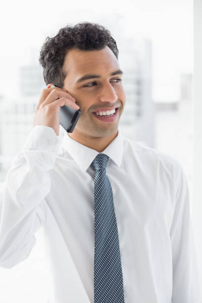 istock Smiling elegant young businessman using cellphone 869419672
