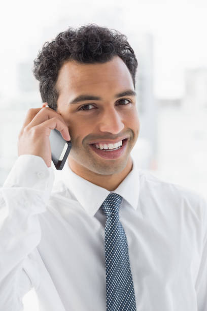istock Smiling elegant young businessman using cellphone 869419678