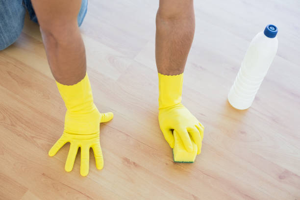 istock Yellow gloved hands with sponge cleaning the floor 869437358