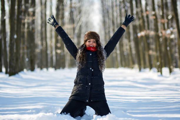 Young woman having fun outdoor in the snow, closeup with selective focus