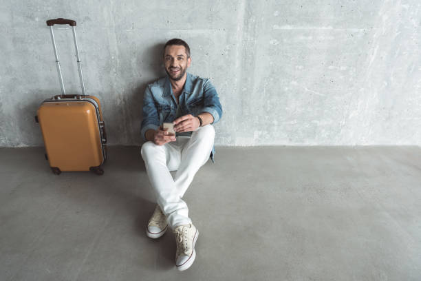istock Cheerful traveler is expressing gladness while using mobile phone 869444858