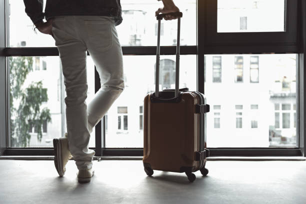 istock Stylish guy carrying his luggage 869447472