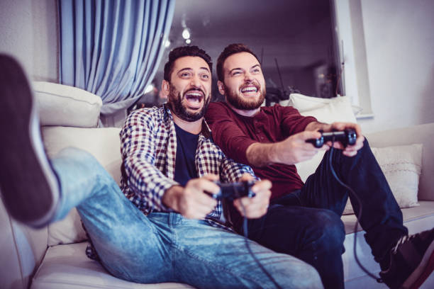 istock Two Excited Friends Playing Video Games 869447560