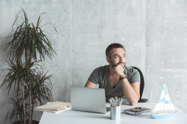 Pensive man with stubble is laboring in office