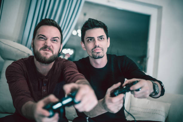 istock Two Excited Friends Playing Video Games 869448162