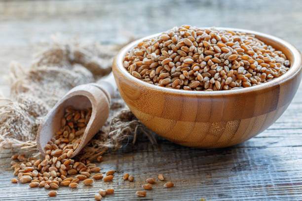 istock Wooden bowl with organic wheat. 869451586