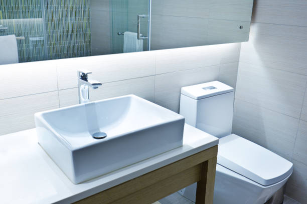 A contemporary modern bathroom design. Featuring vanity and sink counter and the toilet. A newly remodeled bathroom.