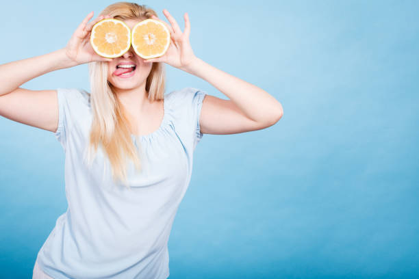 istock Girl covering her eyes with grapefruits 869455568