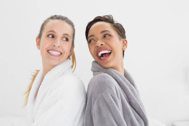 istock Two happy young female friends in bathrobes 869455636